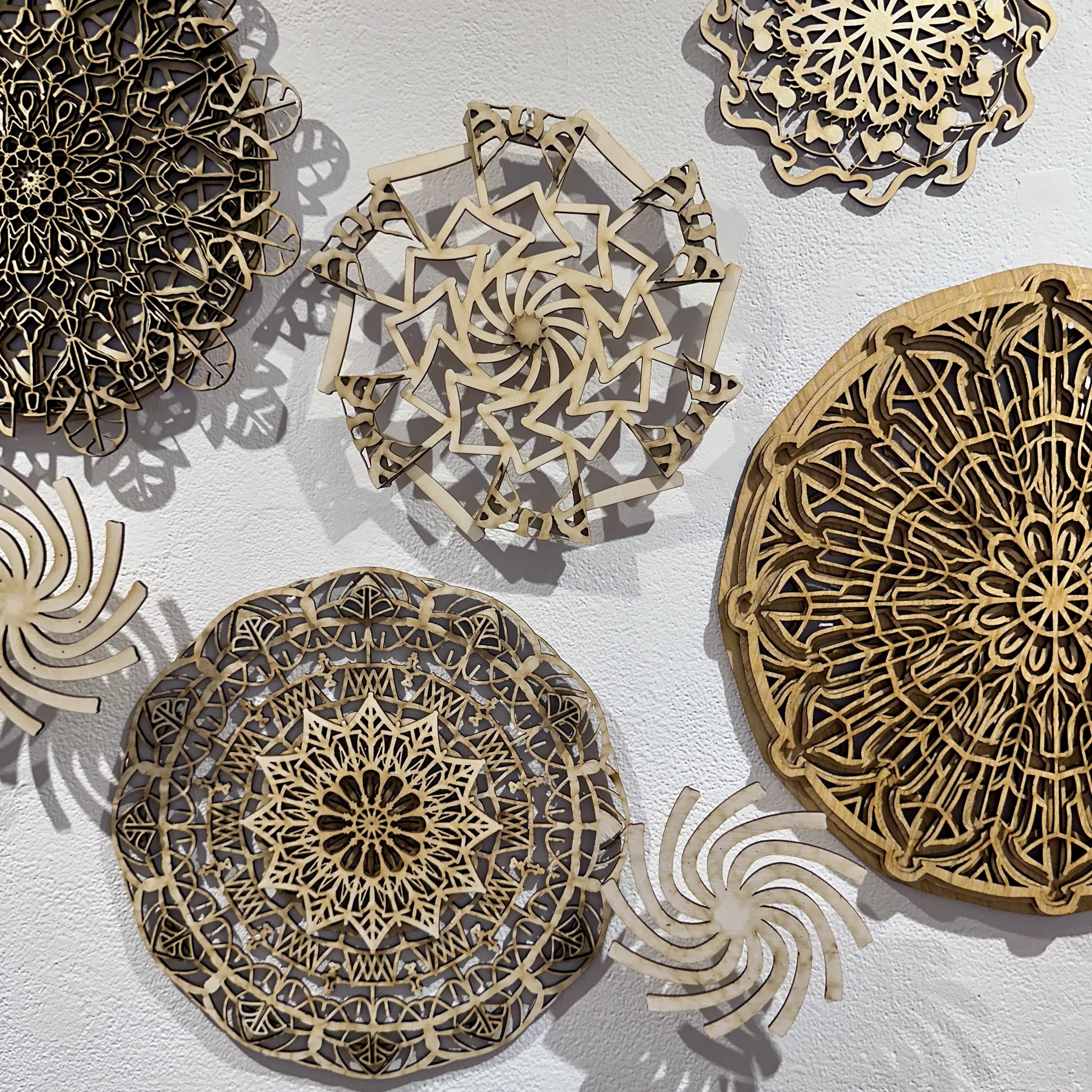 Wall detail of laser-cut works from Inverted Normals.