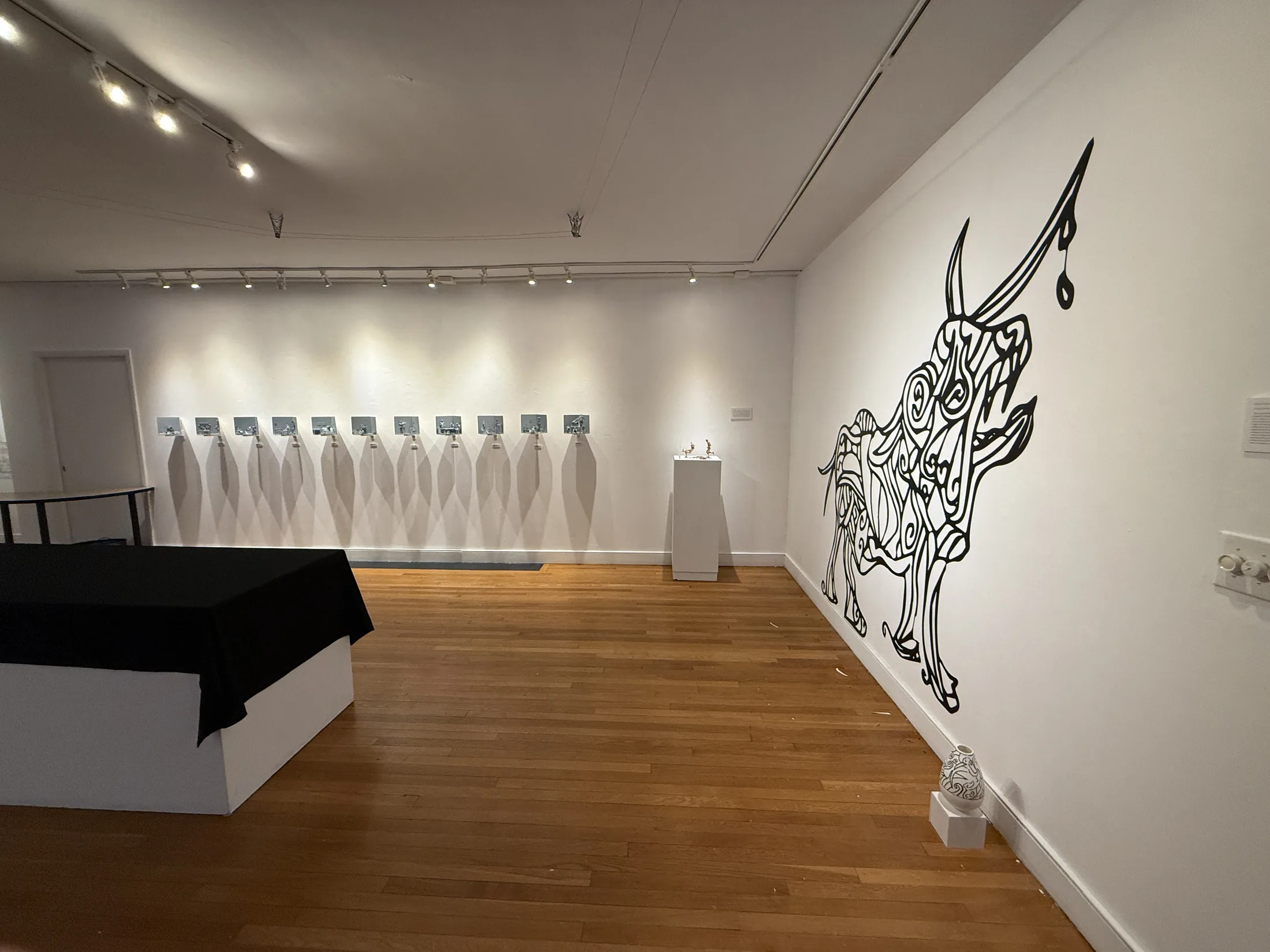 Installation view of Pixels to Pieces with large wall drawing and plinths.