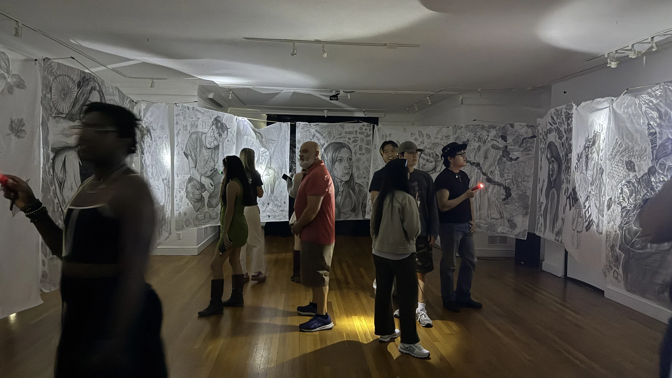 Visitors viewing student drawings in Cave of Forgotten Dreams.