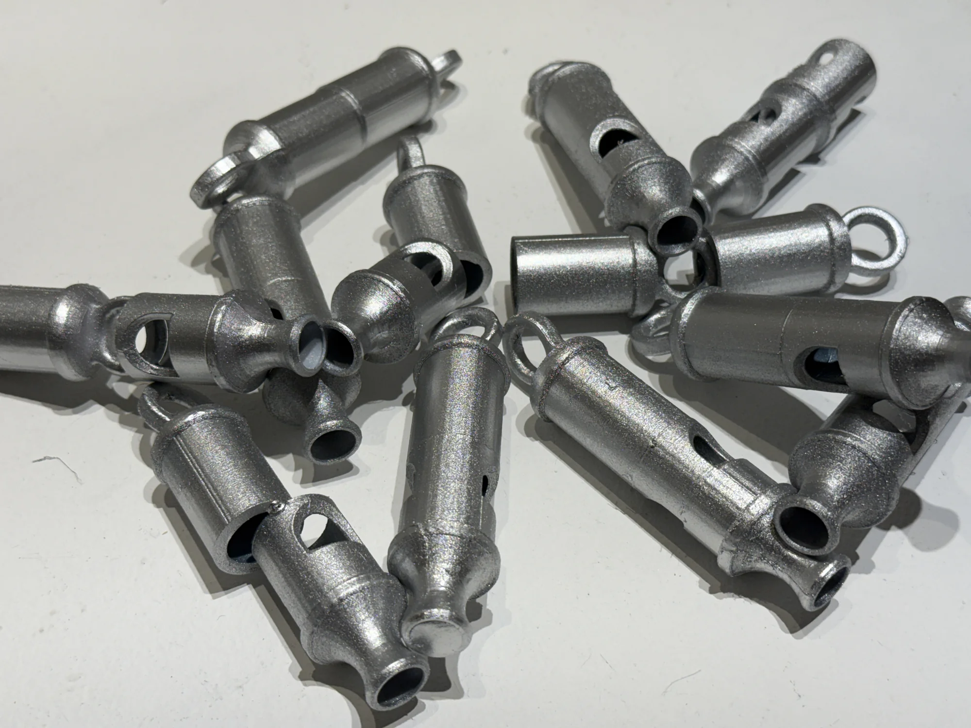 A cluster of small metallic-colored cylindrical forms on a white surface.