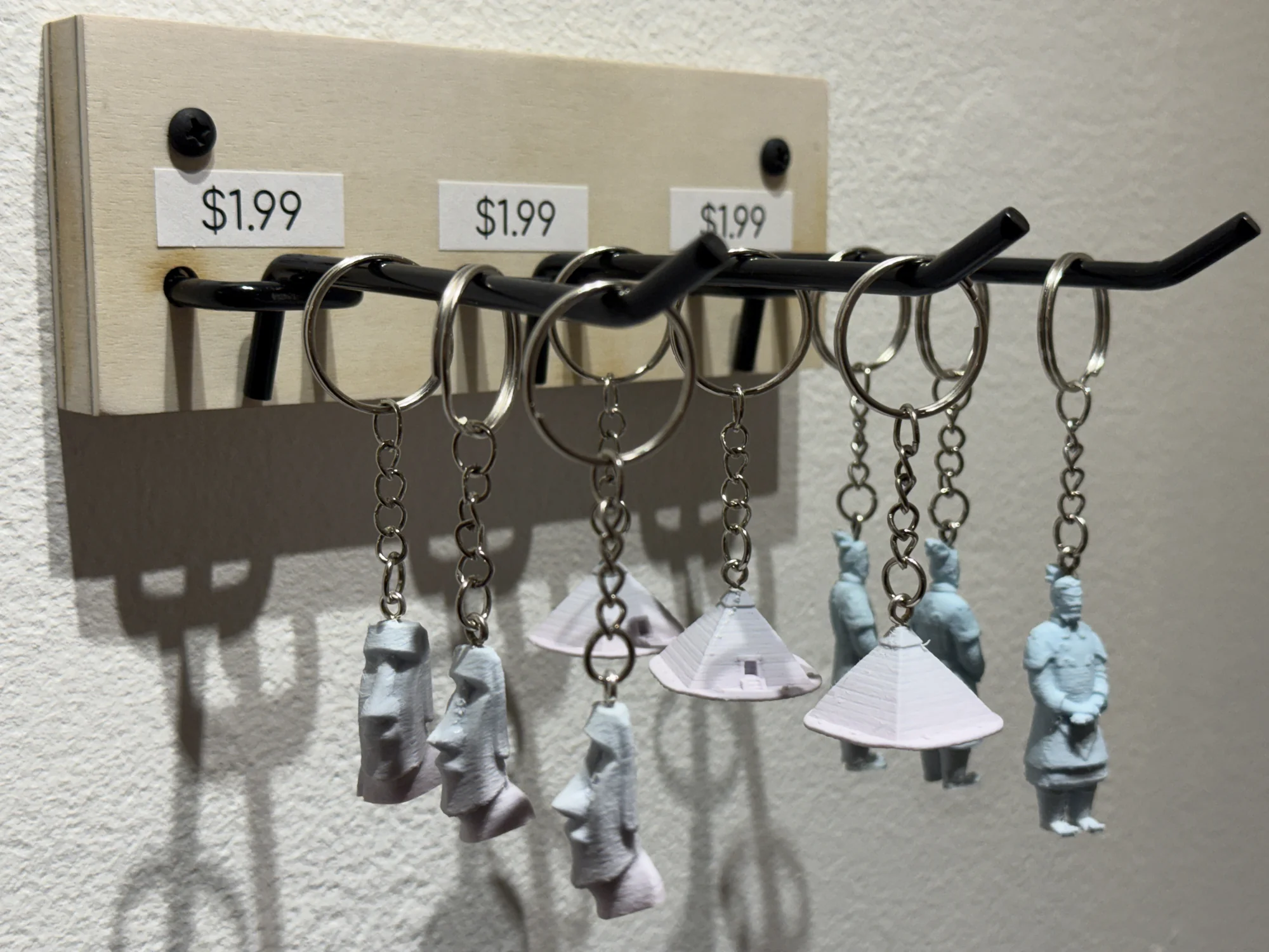 Small pale figurines hang from key rings beneath price labels.