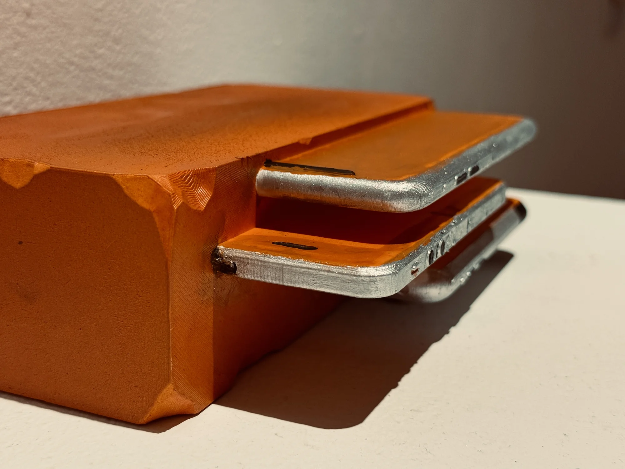Close view of stacked orange trays with metallic-colored handles.